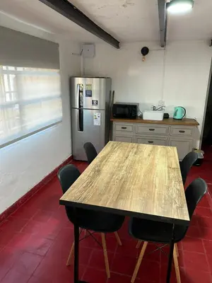 a kitchen with a wooden table and a refrigerator at Casa Henry in Cordoba