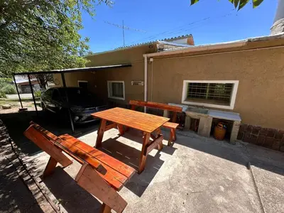 a picnic table and benches in front of a building at La Maguada in Tanti
