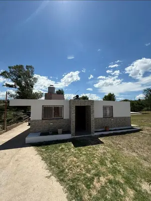 a building with a garage in the middle of a field at La Gringa in Tanti