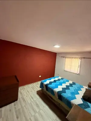 a bedroom with a bed and a red wall at La Gringa in Tanti