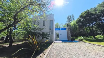 a small white house in the middle of a yard at Zeus in Las Chacras (La Paz)