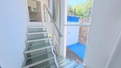 a stairway leading to a room with a glass door at Zeus in Las Chacras (La Paz)