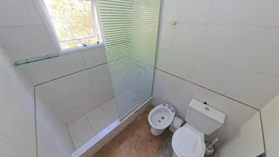 a bathroom with a toilet and a shower and a window at Zeus in Las Chacras (La Paz)