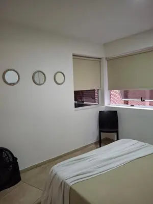 a room with a bed and a chair and two mirrors at Departamento en Nueva Cordobá, CORDOBA in Cordoba