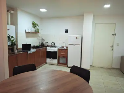 a kitchen with a table and a white refrigerator at Departamento en Nueva Cordobá, CORDOBA in Cordoba