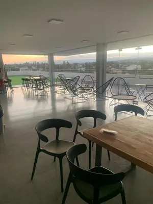 a room with tables and chairs and a table and chairs at Departamento en el centro de Carlos Paz con pileta in Villa Carlos Paz