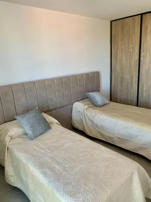two beds sitting next to each other in a room at Departamento en el centro de Carlos Paz con pileta in Villa Carlos Paz