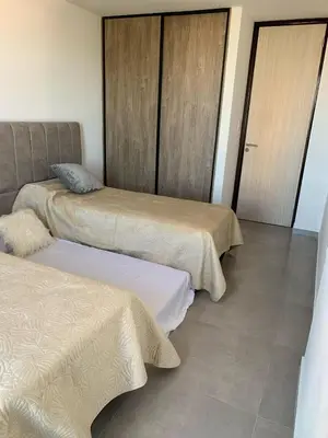 a room with two beds and two doors at Departamento en el centro de Carlos Paz con pileta in Villa Carlos Paz