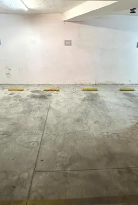 an empty parking garage with yellow poles on the floor at Departamento en el centro de Carlos Paz con pileta in Villa Carlos Paz