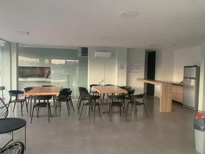 a room with tables and chairs and a refrigerator at Departamento en el centro de Carlos Paz con pileta in Villa Carlos Paz