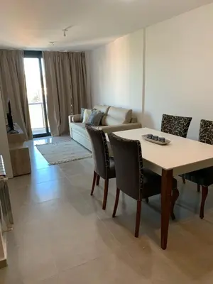 a living room with a table and chairs and a couch at Departamento en el centro de Carlos Paz con pileta in Villa Carlos Paz