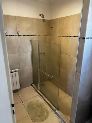 a shower with a glass door in a bathroom at Santa Rita Loft in Villa Carlos Paz