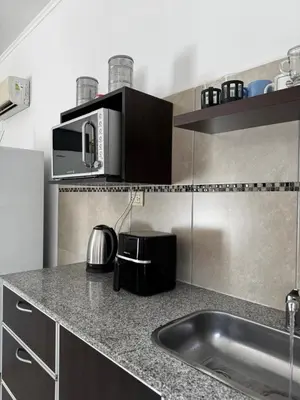 a kitchen with a sink and a microwave at Santa Rita Loft in Villa Carlos Paz