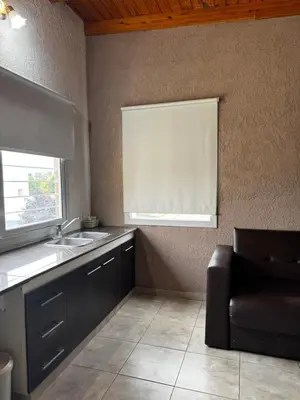 a kitchen with a sink and a window and a chair at Santa Rita Loft in Villa Carlos Paz