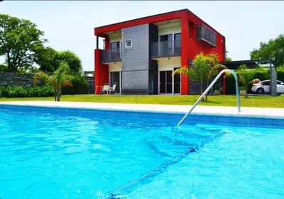a swimming pool in front of a house at Rumipaz in Villa Rumipal