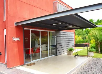 awning over a patio of a red building at Rumipaz in Villa Rumipal
