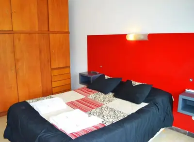 a bedroom with a bed with a red headboard at Rumipaz in Villa Rumipal
