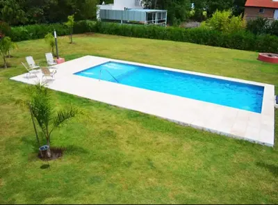 a swimming pool in the middle of a yard at Rumipaz in Villa Rumipal