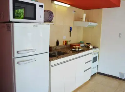 a kitchen with a white refrigerator and a microwave at Rumipaz in Villa Rumipal