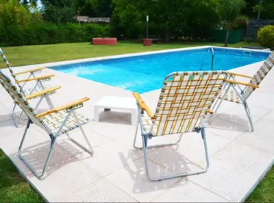 two chairs and a table next to a swimming pool at Rumipaz in Villa Rumipal
