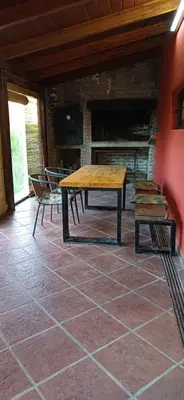 a table and two chairs in a room with a fireplace at Cabaña Benitto in Potrero de Garay