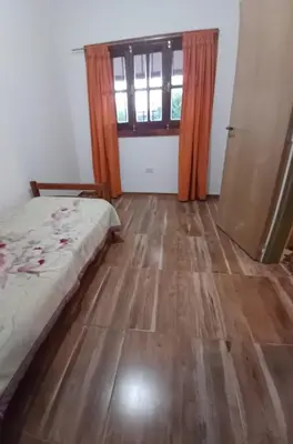 a bedroom with a bed and a wooden floor at Cabaña Benitto in Potrero de Garay