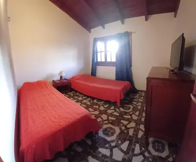 a bedroom with a red bed and a window at Cabaña Benitto in Potrero de Garay