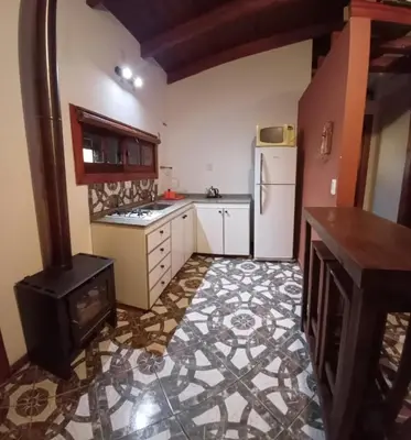 a kitchen with a stove and a refrigerator at Cabaña Benitto in Potrero de Garay