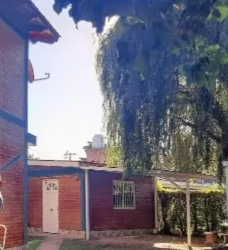 a building with a tree hanging over the side of it at Departamentos Mis 5 Soles in Villa Cura Brochero