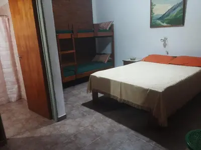 a bedroom with a bed and a ladder and a chair at Departamentos Mis 5 Soles in Villa Cura Brochero