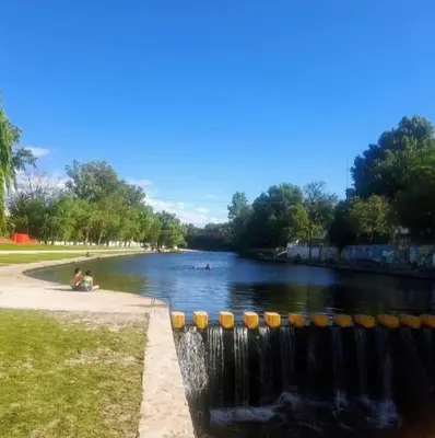 a body of water with people swimming in it at Departamentos Mis 5 Soles in Villa Cura Brochero