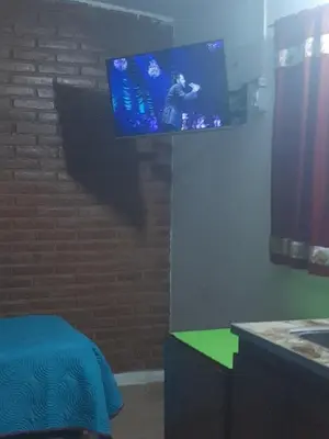 a bedroom with a tv on a brick wall at Departamentos Mis 5 Soles in Villa Cura Brochero