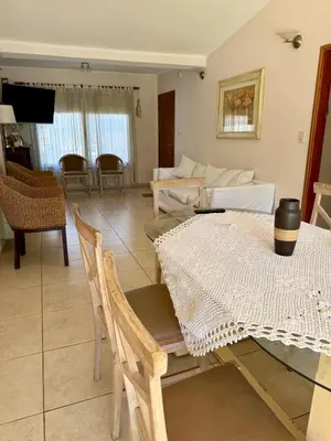 a living room with a table and a couch at Casa Impecable, Piscina, Cochera, a 100 m del Lago, Familias in Villa Carlos Paz