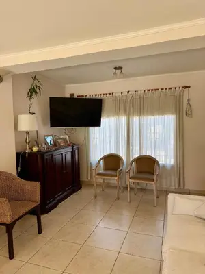 a living room with two chairs and a flat screen tv at Casa Impecable, Piscina, Cochera, a 100 m del Lago, Familias in Villa Carlos Paz