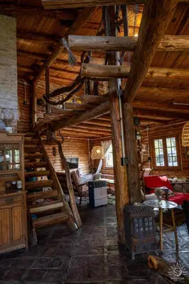 a room with a spiral staircase in a log cabin at Intihuasi Casa del Sol in Atos Pampa