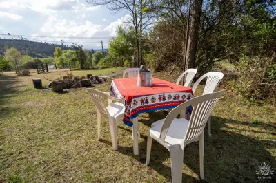 a table with white chairs and a red table cloth at Intihuasi Casa del Sol in Atos Pampa