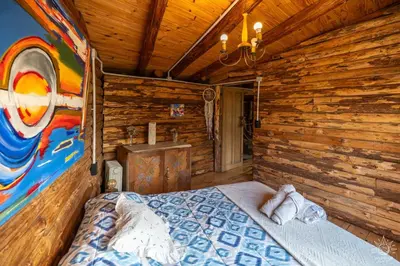 a bedroom with a bed in a wooden cabin at Intihuasi Casa del Sol in Atos Pampa