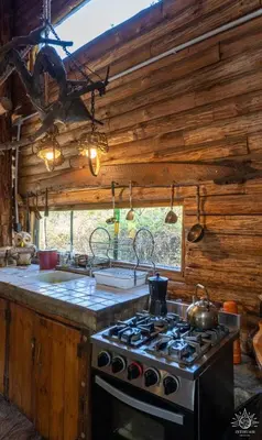 a kitchen with a stove top oven in a cabin at Intihuasi Casa del Sol in Atos Pampa