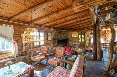 a living room with a fireplace in a log cabin at Intihuasi Casa del Sol in Atos Pampa