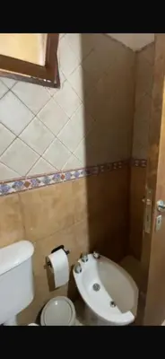 a small bathroom with a toilet and a sink at Cabañas Gran Aldea in Mina Clavero