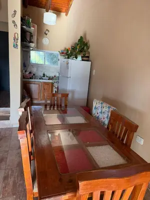 a kitchen with a dining table and a refrigerator at Casa en Cabalango in Cavalango