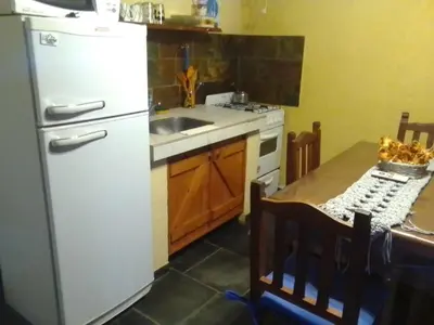 a kitchen with a white refrigerator and a sink at Cabañas Ojo de Agua in Trapiche