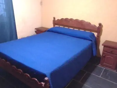 a bedroom with a blue bed with a wooden frame at Cabañas Ojo de Agua in Trapiche