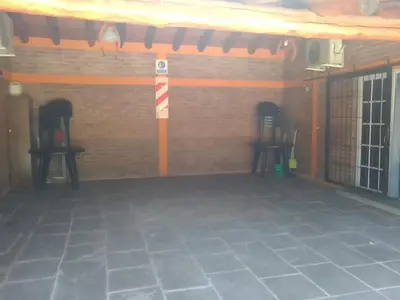 a room with two chairs and a brick wall at Cabañas Ojo de Agua in Trapiche