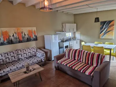 a living room with two couches and a kitchen at La Insolente in Villa Yacanto
