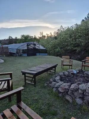 a picnic table and a fire pit with a tent at La Insolente in Villa Yacanto