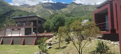 a house with mountains in the background at Crepúsculo Serrano in Merlo