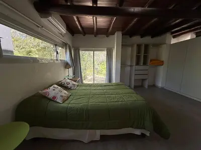 a bedroom with a green bed and a window at Gea in Las Chacras (La Paz)