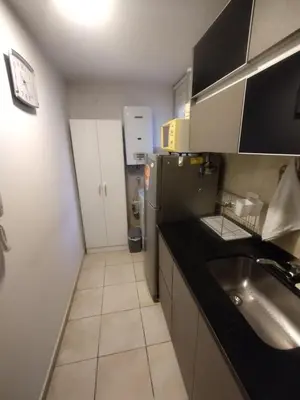 a small kitchen with a sink and a refrigerator at Confort en Barrio General Paz in Cordoba