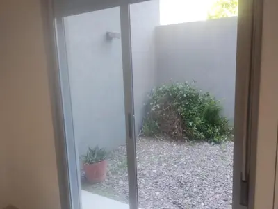 a sliding glass door with a plant in a yard at Confort en Barrio General Paz in Cordoba